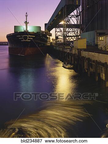 Stock Photo - Cargo ship in harbor at night. Fotosearch