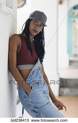 Stock Image - Casual Mixed Race woman leaning on wall. Fotosearch