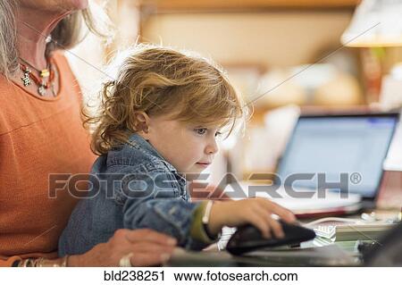 Caucasian baby boy in lap of grandmother using computer mouse View Large Photo Image Stock Image - Caucasian baby boy in lap of grandmother using computer mouse. Fotosearch