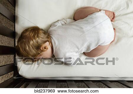 Caucasian baby boy sleeping in crib View Large Photo Image Stock Photo - Caucasian baby boy sleeping in crib. Fotosearch