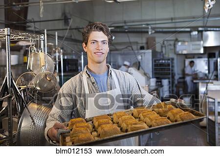 Caucasian baker carrying tray of croissants in bakery View Large Photo Image Stock Image - Caucasian baker carrying tray of croissants in bakery. Fotosearch