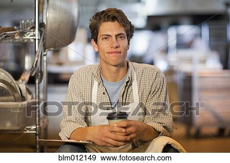 Caucasian baker drinking coffee in bakery View Large Photo Image Stock Photo - Caucasian baker drinking coffee in bakery. Fotosearch