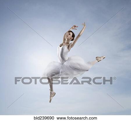Stock Image - Caucasian ballerina dancing in sky. Fotosearch