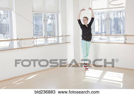 Stock Image - Caucasian ballerina practicing in studio. Fotosearch