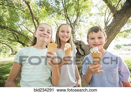Caucasian boy and girls eating ice cream cones View Large Photo Image Stock Image - Caucasian boy and girls eating ice cream cones. Fotosearch