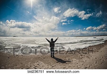 Stock Image - Caucasian boy cheering on ocean beach. Fotosearch