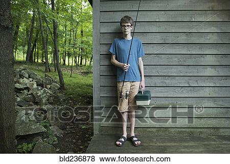 Caucasian boy holding fishing rod at cabin View Large Photo Image Stock Photo - Caucasian boy holding fishing rod at cabin. Fotosearch
