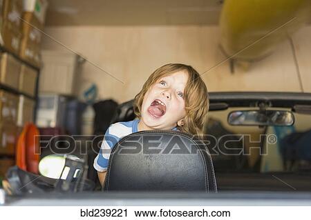 Caucasian boy making a face in convertible car View Large Photo Image Stock Image - Caucasian boy making a face in convertible car. Fotosearch