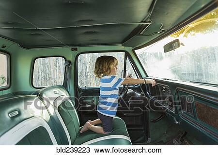 Stock Image - Caucasian boy playing in truck. Fotosearch