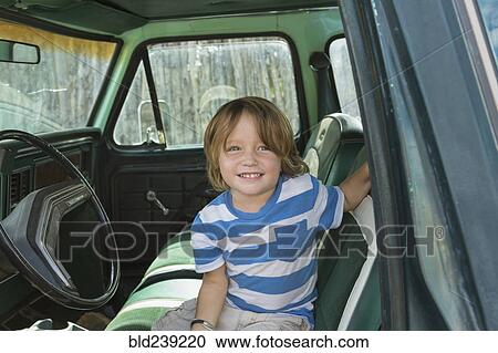 Caucasian boy sitting in truck View Large Photo Image Stock Image - Caucasian boy sitting in truck. Fotosearch