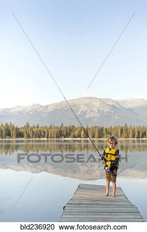 Caucasian boy standing on dock at lake holding fishing rod View Large Photo Image Stock Image - Caucasian boy standing on dock at lake holding fishing rod. Fotosearch