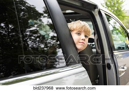 Stock Photo - Caucasian boy waiting in mini-van. Fotosearch