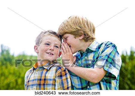 Caucasian boy whispering to brother View Large Photo Image Stock Image - Caucasian boy whispering to brother. Fotosearch