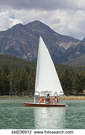 Stock Image - Caucasian boys and girl sailing on lake. Fotosearch