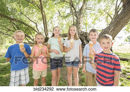 Stock Image - Caucasian boys and girls eating ice cream cones. Fotosearch