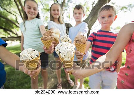 Stock Image - Caucasian boys and girls showing ice cream cones. Fotosearch