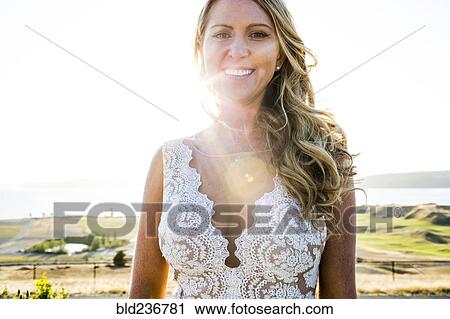 Stock Image - Caucasian bride smiling on sunny day. Fotosearch