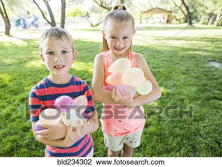 Caucasian brother and sister holding water balloons View Large Photo Image Stock Image - Caucasian brother and sister holding water balloons. Fotosearch