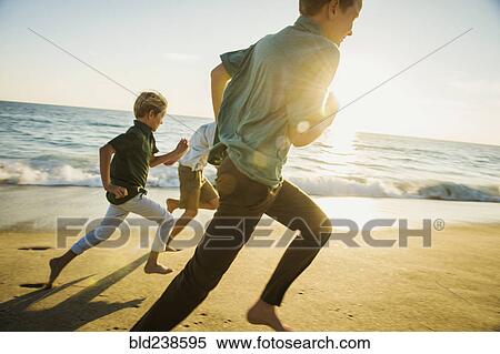 Caucasian brothers running on beach View Large Photo Image Stock Photography - Caucasian brothers running on beach. Fotosearch