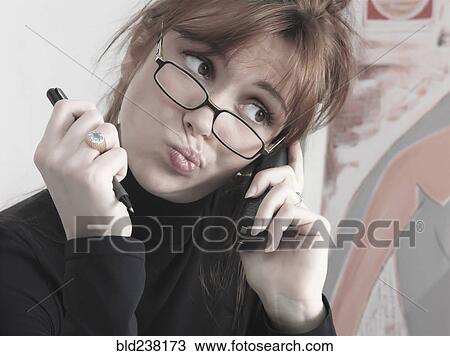 Stock Image - Caucasian businesswoman talking on telephone making a face. Fotosearch