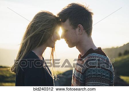 Stock Image - Caucasian couple face to face in landscape. Fotosearch