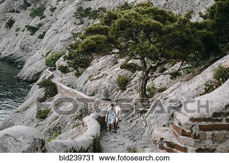 Caucasian couple hiking on cliff near lake View Large Photo Image Stock Image - Caucasian couple hiking on cliff near lake. Fotosearch