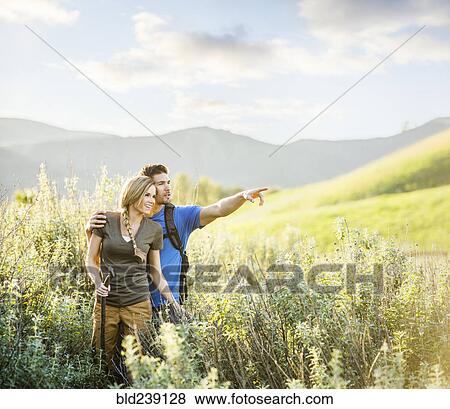 Stock Photo - Caucasian couple hiking on hill. Fotosearch
