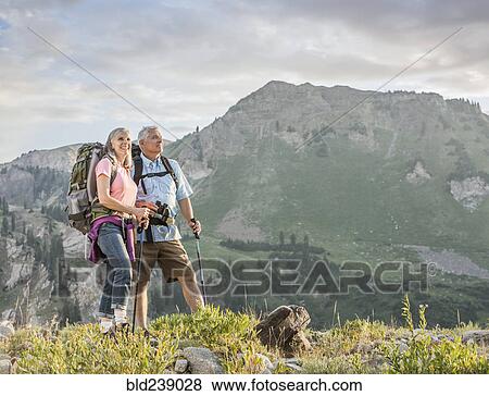 Stock Photo - Caucasian couple hiking on mountain. Fotosearch