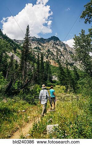 Caucasian couple hiking on path in mountains View Large Photo Image Stock Photograph - Caucasian couple hiking on path in mountains. Fotosearch