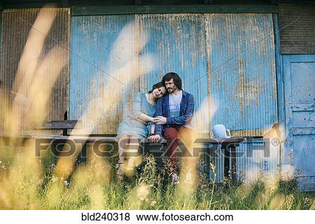 Caucasian couple holding hands sitting on table outdoors View Large Photo Image Stock Photo - Caucasian couple holding hands sitting on table outdoors. Fotosearch