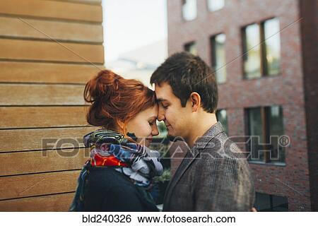 Stock Photograph - Caucasian couple hugging face to face in city. Fotosearch