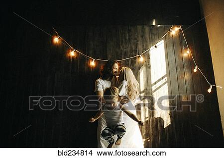 Caucasian couple hugging near boy under string lights View Large Photo Image Picture - Caucasian couple hugging near boy under string lights. Fotosearch