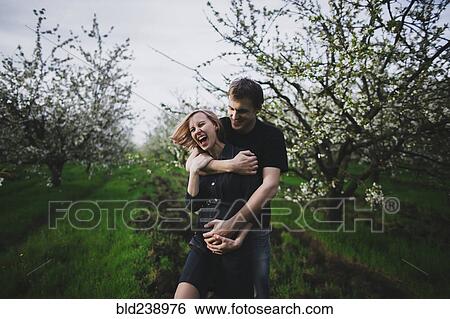 Caucasian couple hugging near trees View Large Photo Image Stock Photograph - Caucasian couple hugging near trees. Fotosearch