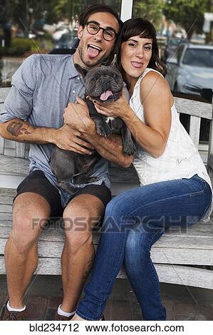 Stock Image - Caucasian couple imitating dog with tongue out. Fotosearch