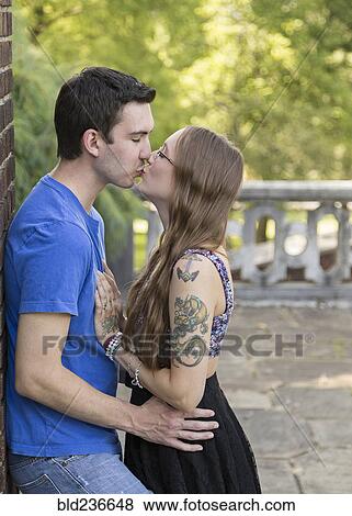 Stock Photo - Caucasian couple kissing in park. Fotosearch
