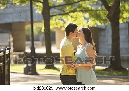 Stock Photography - Caucasian couple kissing in park. Fotosearch