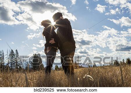 Caucasian couple kissing in sunny field View Large Photo Image Stock Photography - Caucasian couple kissing in sunny field. Fotosearch
