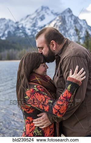 Picture - Caucasian couple kissing near river. Fotosearch