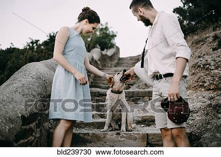 Caucasian couple playing with dog on stone staircase View Large Photo Image Stock Image - Caucasian couple playing with dog on stone staircase. Fotosearch