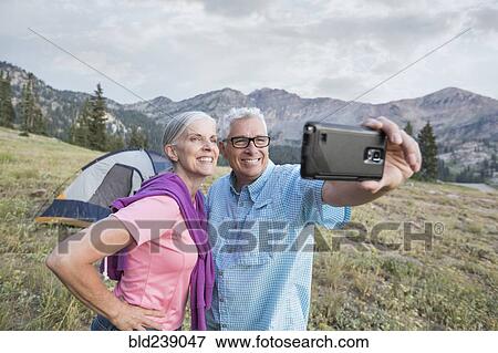 Caucasian couple posing for cell phone selfie on mountain View Large Photo Image Stock Photo - Caucasian couple posing for cell phone selfie on mountain. Fotosearch