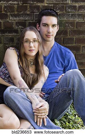 Caucasian couple sitting on ground leaning on wall View Large Photo Image Stock Image - Caucasian couple sitting on ground leaning on wall. Fotosearch