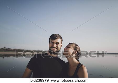 Stock Photo - Caucasian couple smiling near lake. Fotosearch