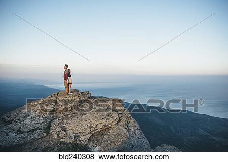 Caucasian couple standing back to back on mountain View Large Photo Image Stock Photo - Caucasian couple standing back to back on mountain. Fotosearch