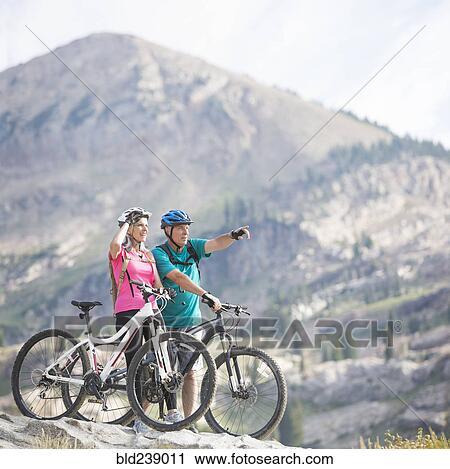 Caucasian couple standing with mountain bikes View Large Photo Image Stock Image - Caucasian couple standing with mountain bikes. Fotosearch