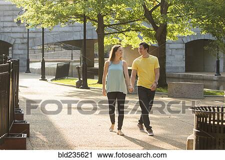 Stock Image - Caucasian couple walking in park. Fotosearch