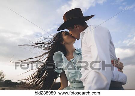 Caucasian cowboy kissing woman in wind View Large Photo Image Stock Photo - Caucasian cowboy kissing woman in wind. Fotosearch