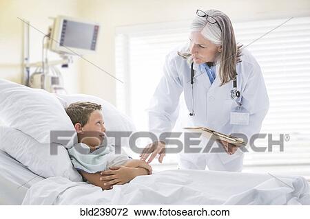 Caucasian doctor talking with boy in hospital bed View Large Photo Image Stock Image - Caucasian doctor talking with boy in hospital bed. Fotosearch