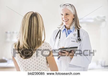 Stock Photography - Caucasian doctor with digital tablet talking to patient. Fotosearch