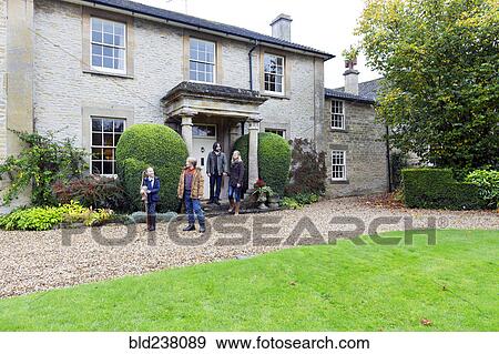 Stock Photo - Caucasian family standing near house. Fotosearch