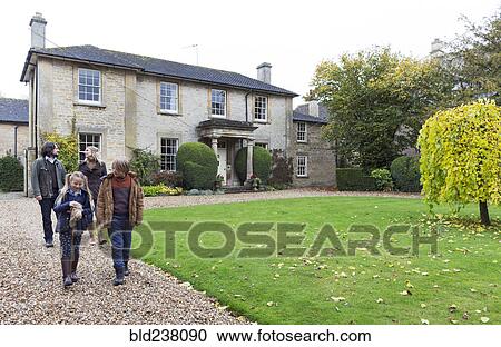 Stock Image - Caucasian family walking on driveway. Fotosearch